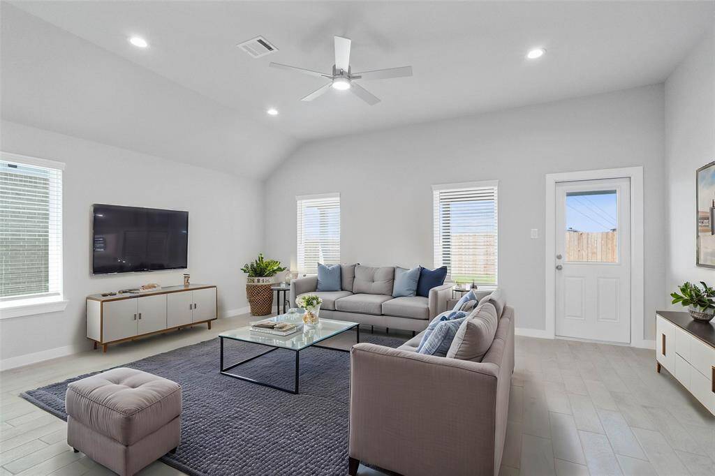 This light and bright spacious family room is the perfect layout for entertaining or just relaxing! Whether it's simply a night in or entertaining family and friends, this home has ample open space for everyone to enjoy! Featuring high ceilings with ceiling fan, wood look tile flooring, large windows with blinds, recessed lighting with wonderful access to your gorgeous kitchen!