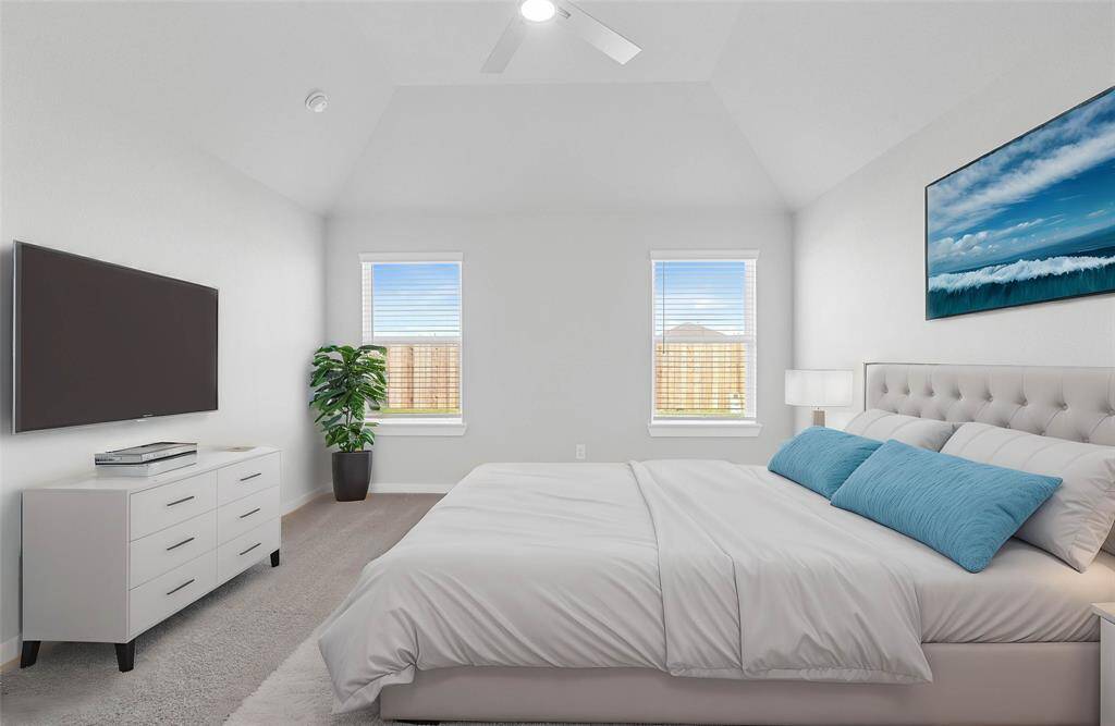 What a wonderful place to come home to, this stunning primary suite greets you with plush carpet flooring, warm custom paint, high ceiling with ceiling fan, large windows with blinds allowing in natural light brightening up this spacious primary bedroom.