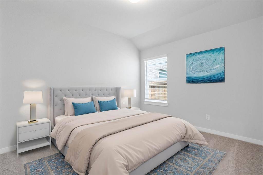 This secondary bedroom features high ceilings, lighting, custom paint, plush carpet, and a large window with privacy blinds!