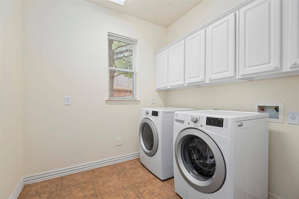 Spacious utility room with ample storage cabinets.