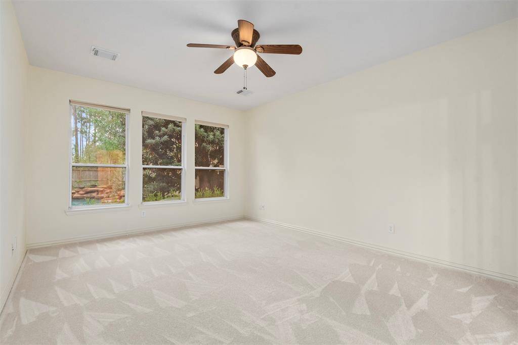 Spacious primary bedroom with stunning backyard views.