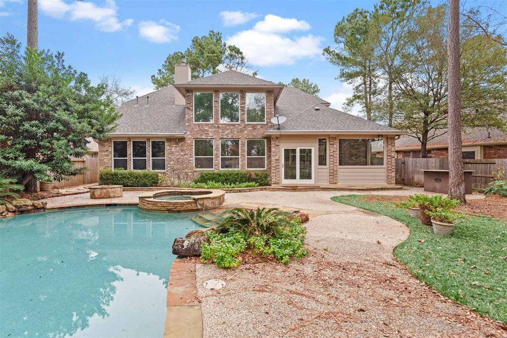 Luxurious pool with a relaxing hot tub and a granite-topped grill area for perfect outdoor entertaining.