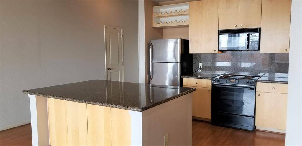 Kitchen with granite counters, SS refrigerator and black appliances. Elec range and built in microwave.