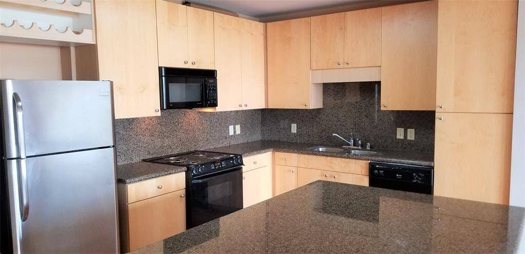 Lots of storage, granite back splash and wine holders above refrigerator.