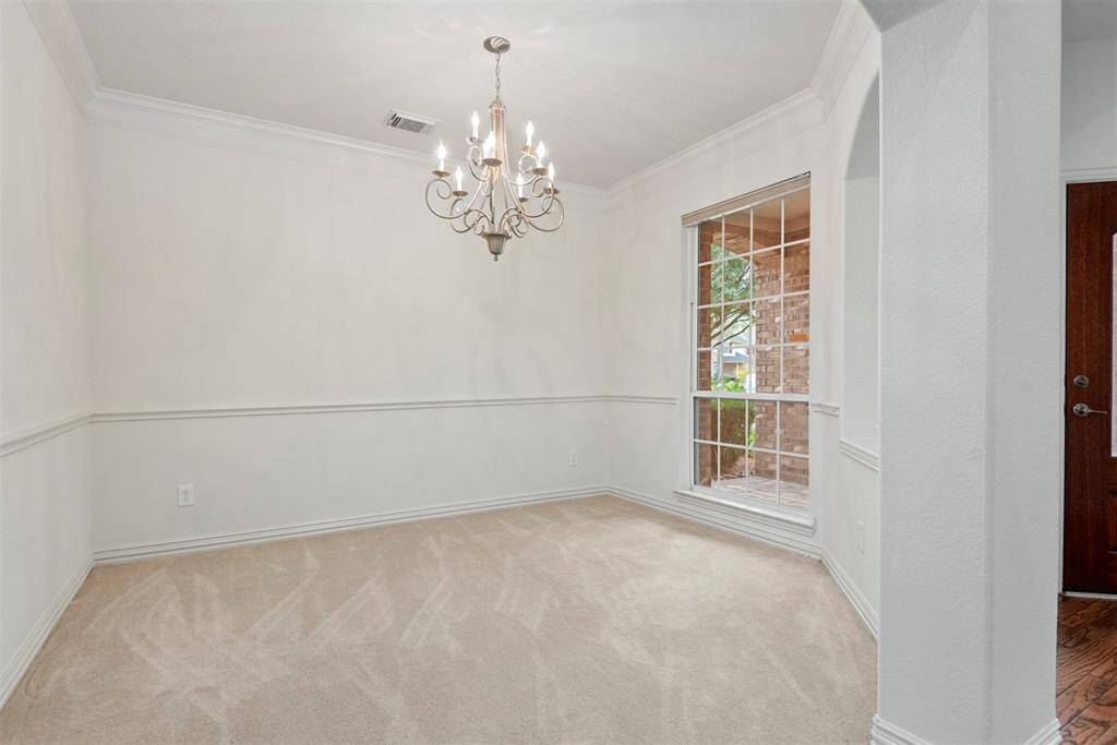 Formal dining room with natural light and a classic chandelier.