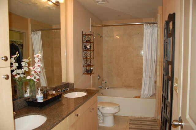 Generous sized full bath with undermount dual sinks, granite counter, stone flooring and on tub/shower surround.