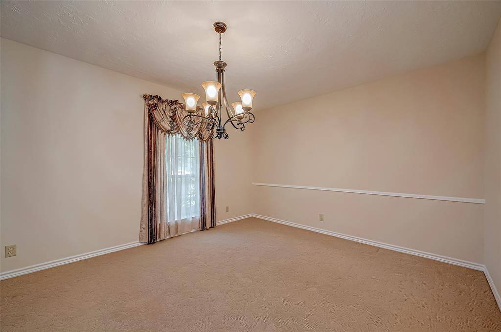 The formal dining room, measuring 14.1 x 11.7, features an elegant oil-rubbed bronze chandelier and classic chair-rail molding. Ideal for entertaining, it accommodates a dining table and offers ample wall space for a China hutch or serving buffet.