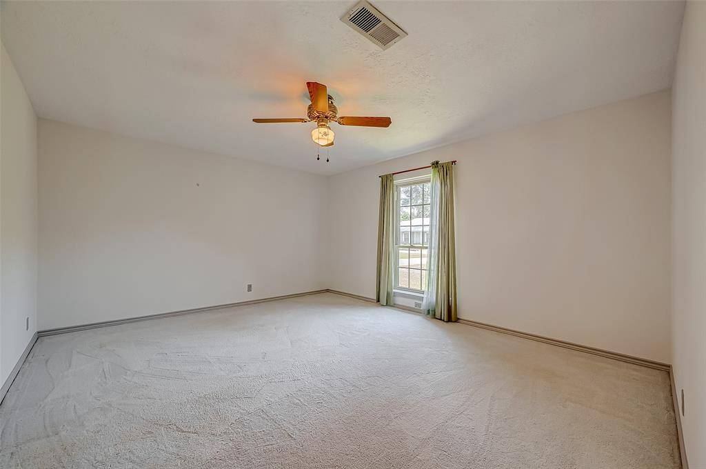 The owner's suite, measuring 15.7 x 13.4, is conveniently located on the first floor and includes a window overlooking the front yard and a ceiling fan for added comfort. The space easily accommodates a king-size bed with nightstands on each side, ideally positioned along the far wall.