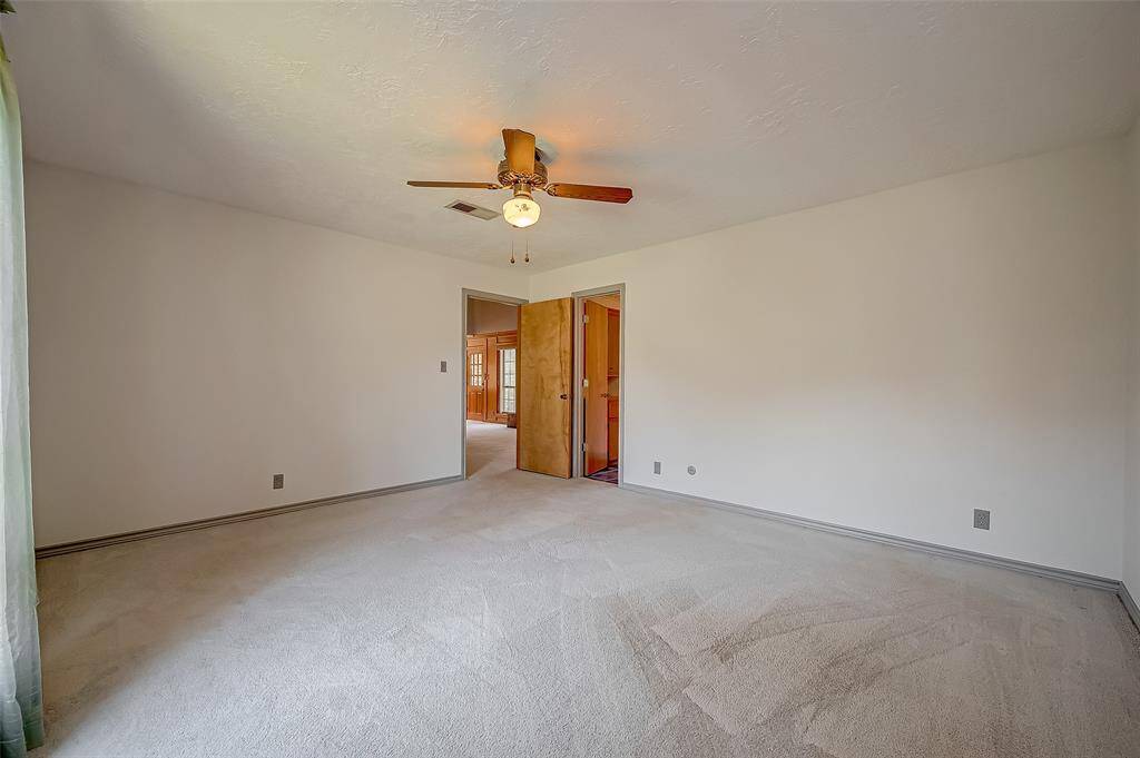 The owner's suite offers ample wall space for arranging and displaying furniture, with room for multiple dressers or bureaus if desired. A doorway on the right leads to the ensuite bath, enhancing the suite's functionality and convenience.