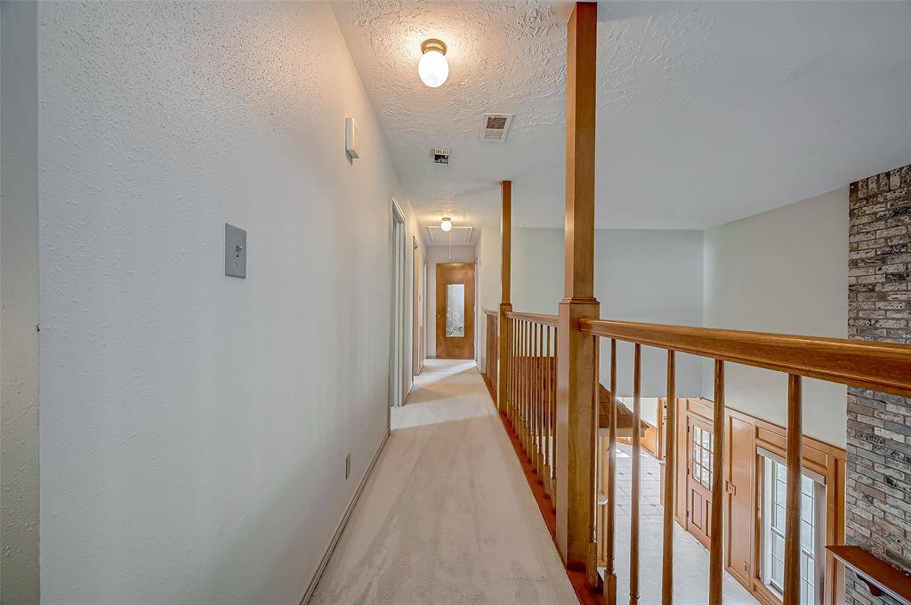 The catwalk hallway on the second floor overlooks the family room below. This level features three bedrooms and one full bathroom.