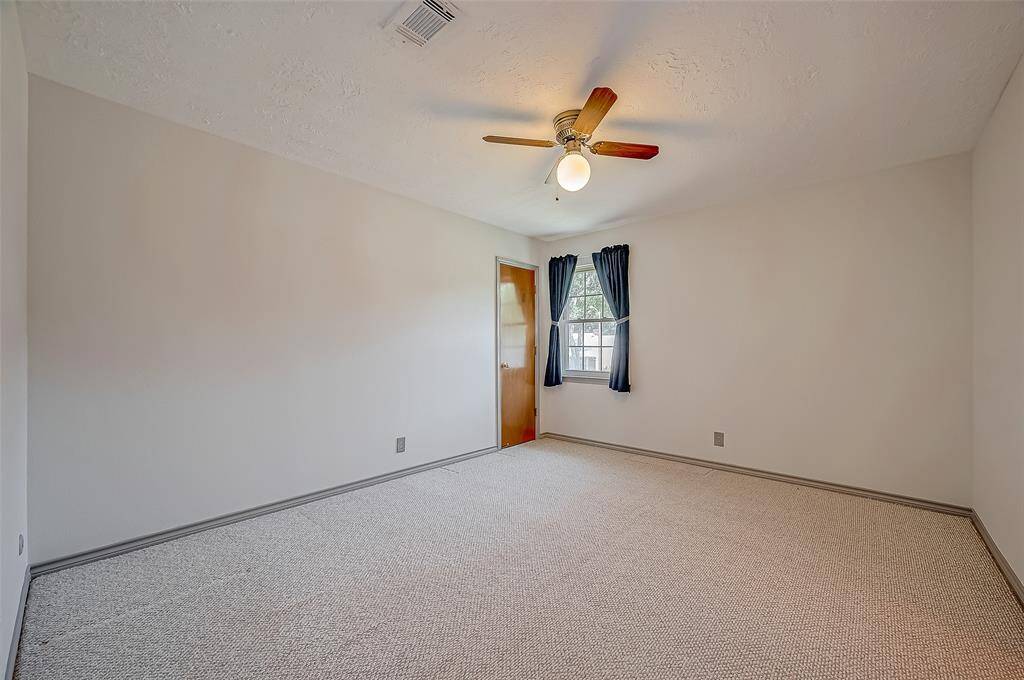 Bedroom #2, measuring 13.7 x 11.7, features a window overlooking the front yard, a ceiling fan, and a lighted walk-in closet. It also offers great wall space for arranging furniture.
