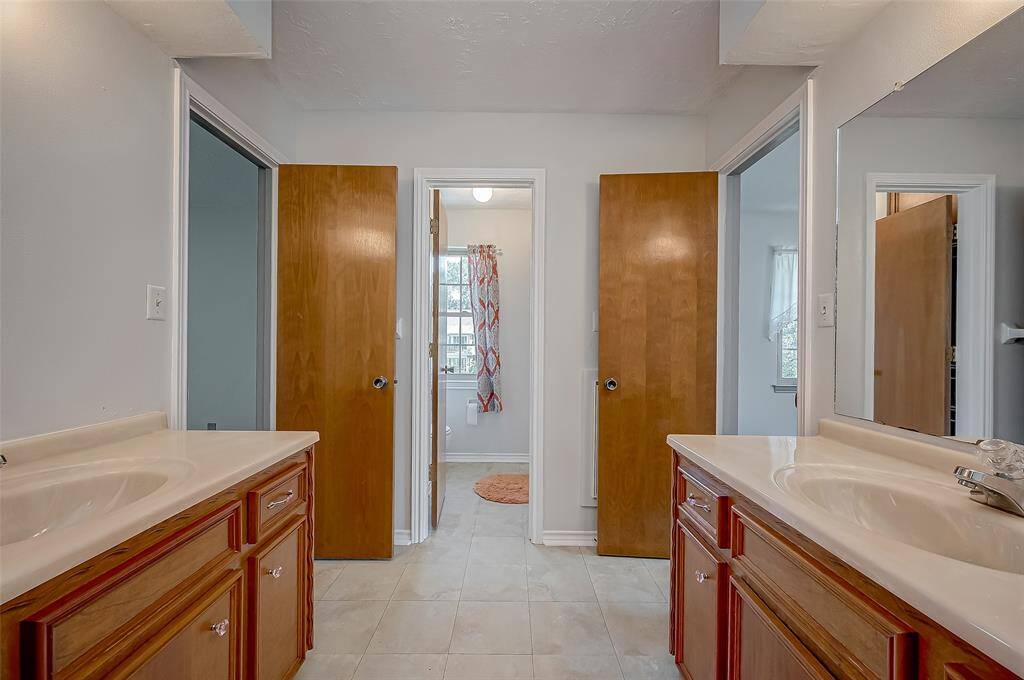 Bath #2 features a separate bathing area with a combination tub and shower, a commode, and a linen closet. This private bathing area is ideal for households with multiple children, providing convenient and efficient use during busy mornings.