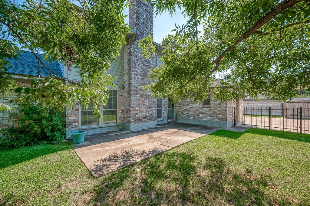 The back of the house features a combination of brick and Hardie board siding. A extensive concrete patio provides an excellent space for entertaining, whether with a patio set or creating an outdoor barbecue area.