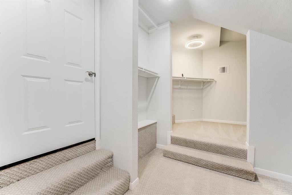 Walk-in closet with built-in shelves, ideal for organized storage.