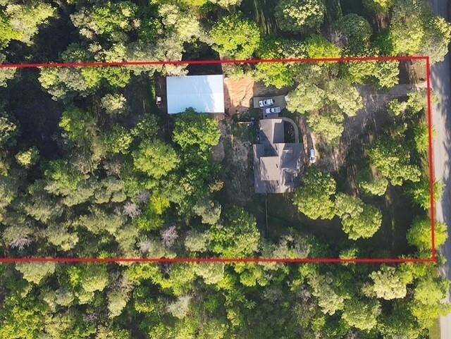 Aerial view shows the property tucked privately on wooded acerage