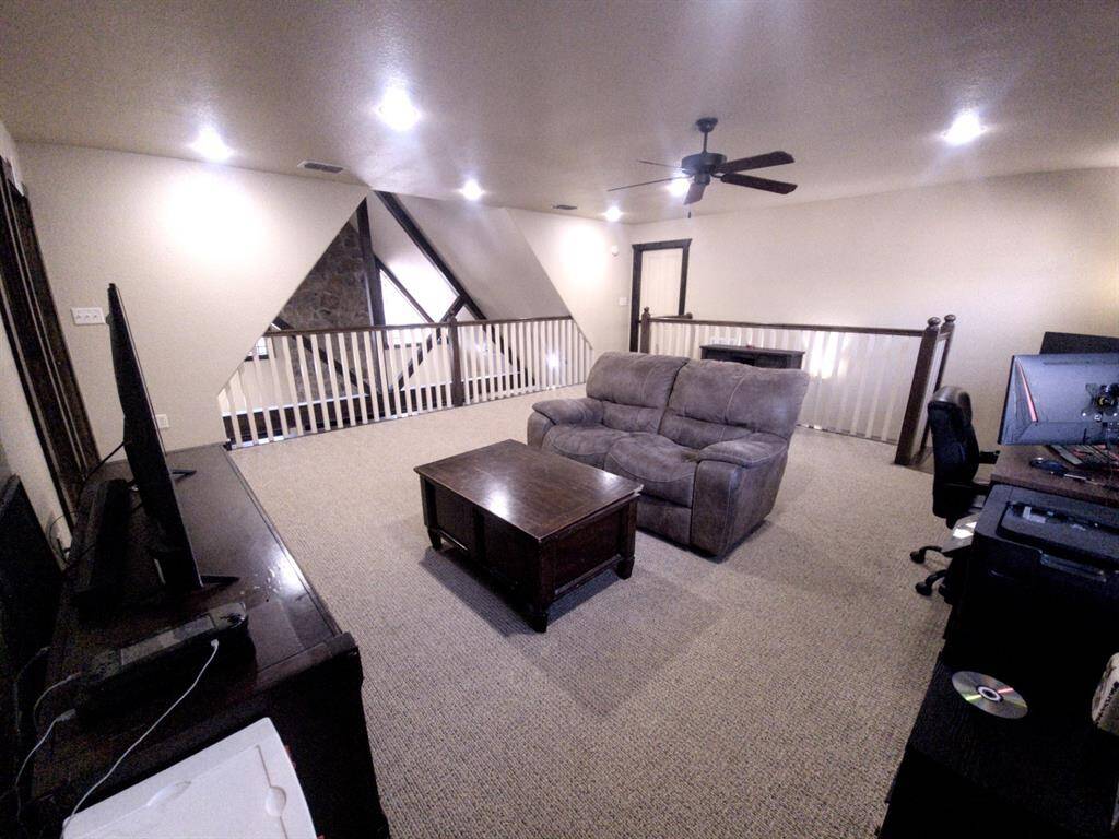 Oversized upstairs game room features recessed lighting and overlooks the downstairs family room