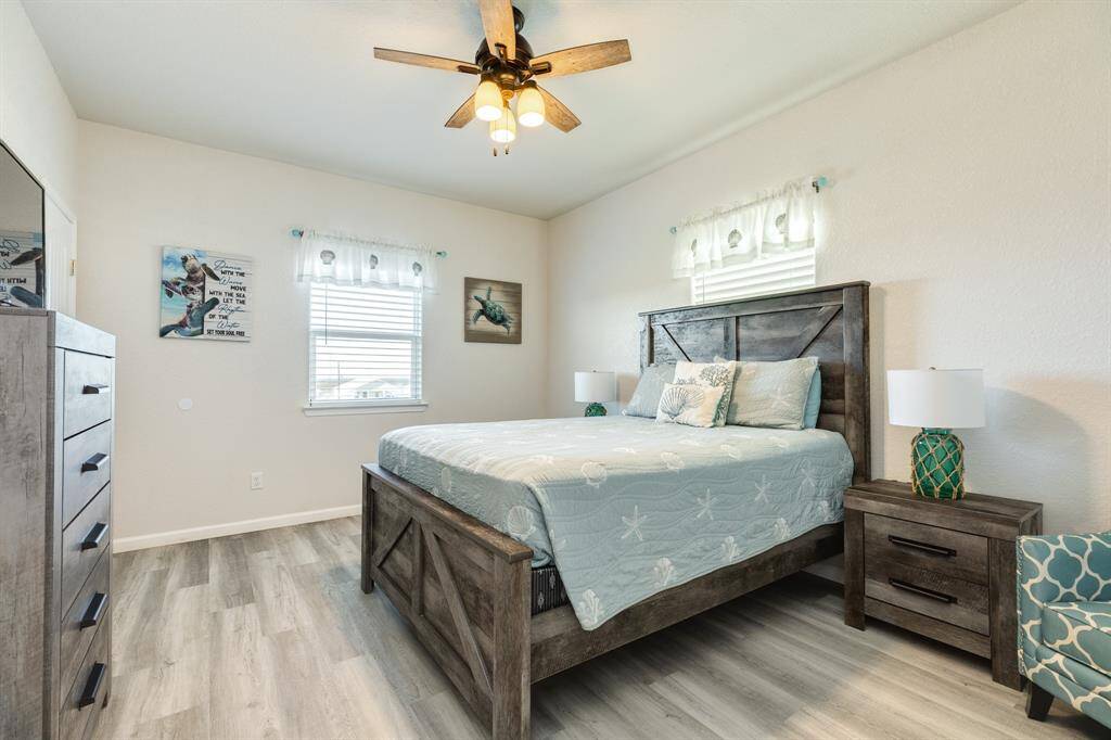 Bright and airy 4th bedroom with modern wood flooring, featuring a cozy bed and stylish furniture. Natural light streams through the windows, enhancing the serene atmosphere. Ideal for comfort and relaxation.