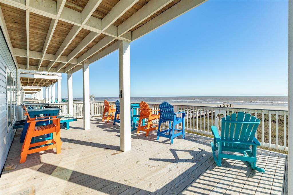 This photo showcases a 16 x 30 beachfront deck with colorful Adirondack chairs, offering stunning Gulf views and a relaxed, inviting atmosphere. Perfect for enjoying sunny days and serene sunsets.