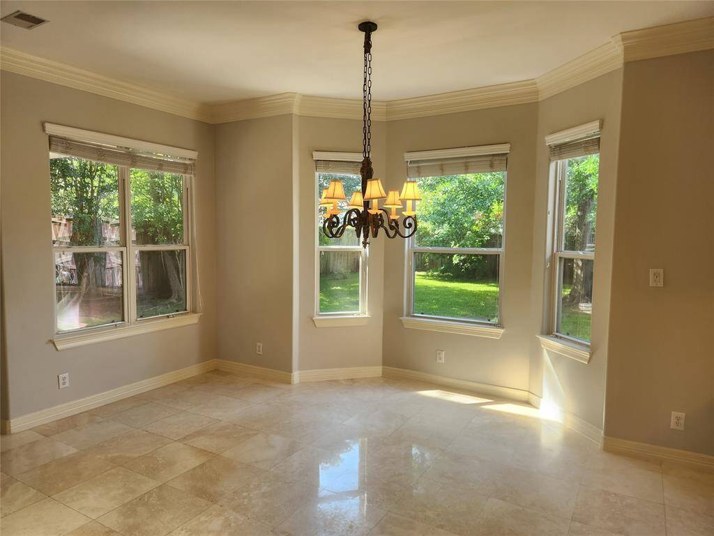 View of breakfast area overlooking the gorgeous green space and tree lined backyard.