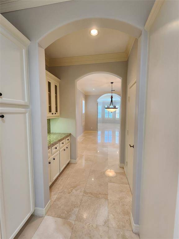 View from the kitchen looking through the butler's pantry and through the formal dining room to the front windows of this home.