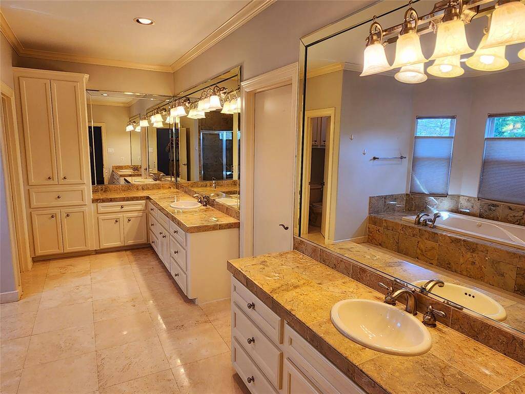 Primary bathroom with double sinks, whirlpool bath and separate shower.