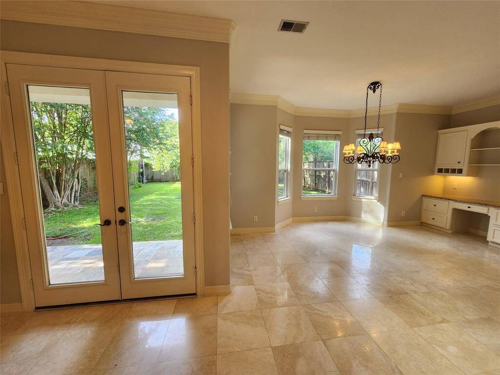 Step right outside of these French doors to your green space backyard.