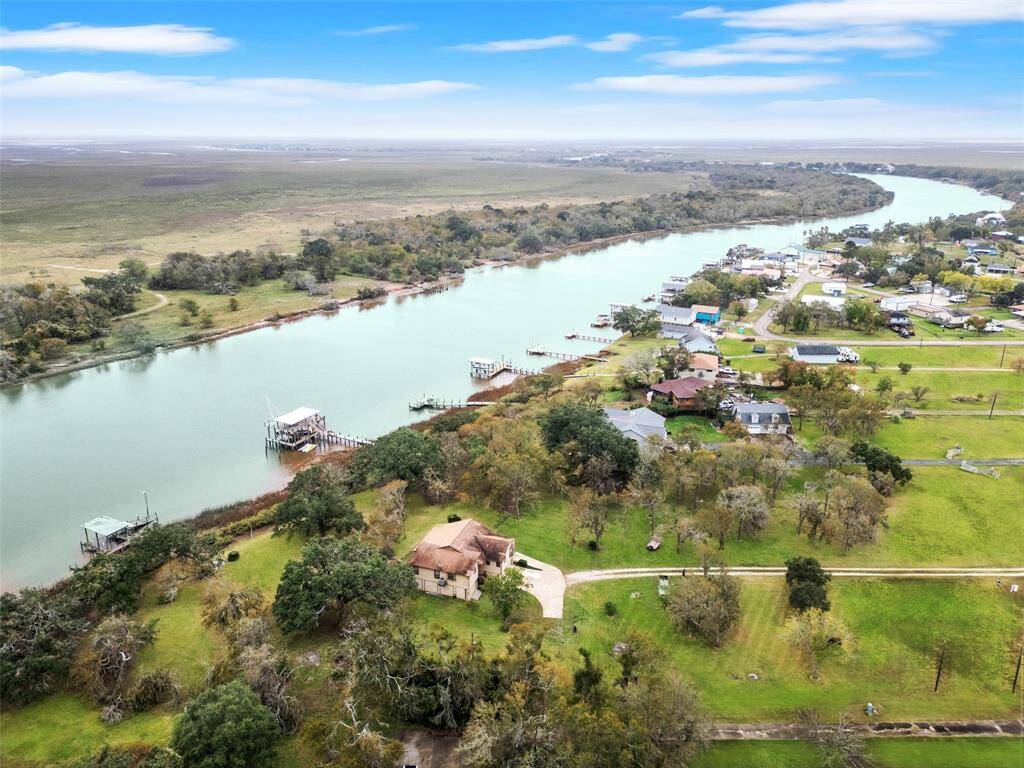 Serene riverside property with lush greenery and dock access to the water, offering tranquil and picturesque living.