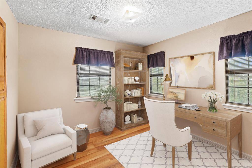 Secondary bedroom features engineered hardwood flooring, neutral paint and plenty of natural light.