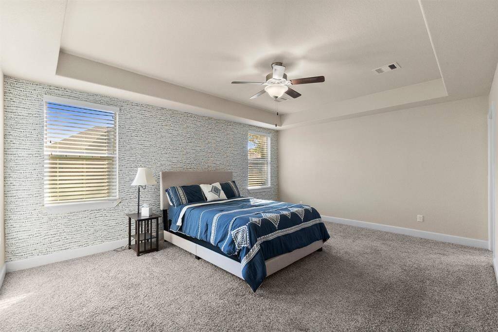 Primary bedroom with contrasting decor and windows