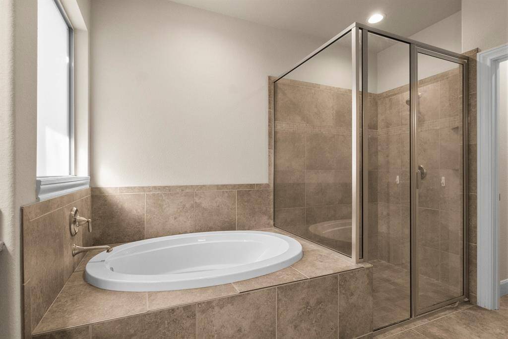 Naturally lit soaking tub and separate shower primary bath