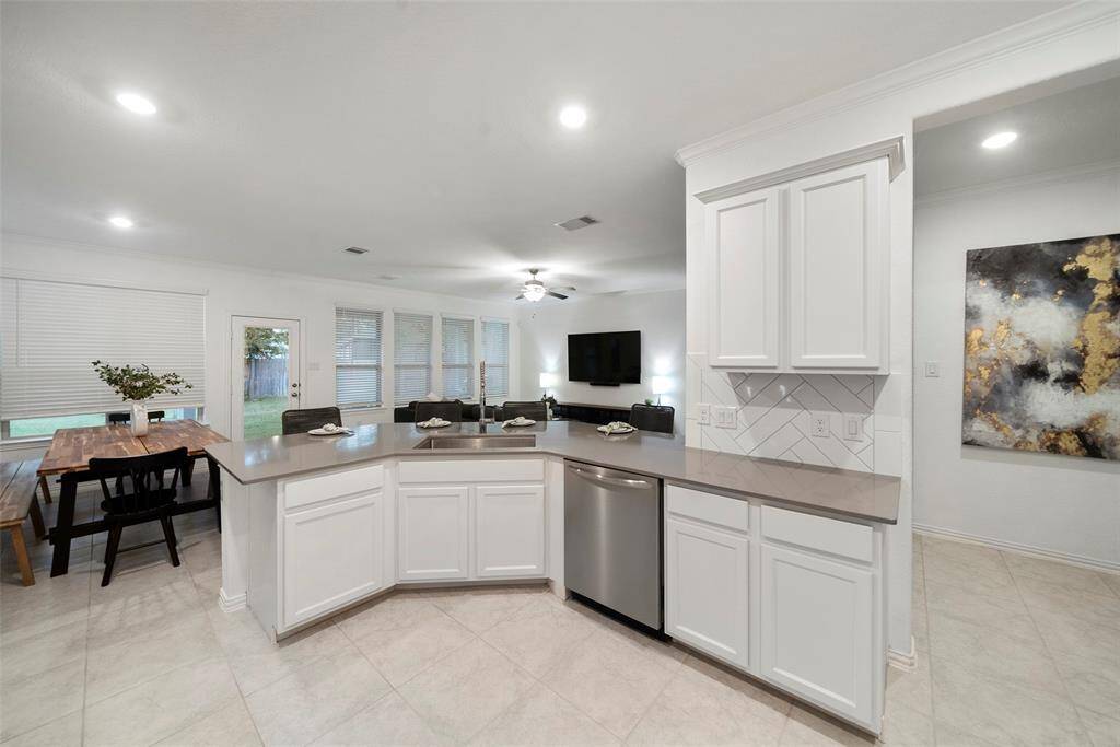 Modern white cabinetry, beautiful herringbone pattern backsplash and separate dining area.