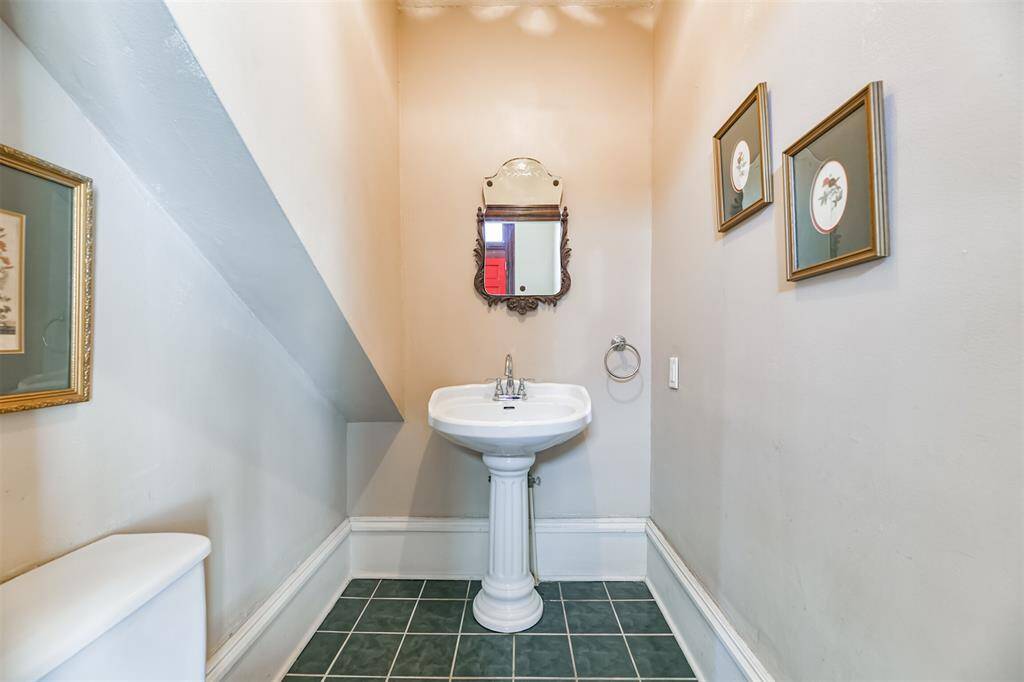 With all bedrooms being on the upper levels, it is rare to find a home with a first-floor bathroom! This half bathroom with a pedestal sink is tucked between the kitchen and family room, near the entrance from the rear porch.
