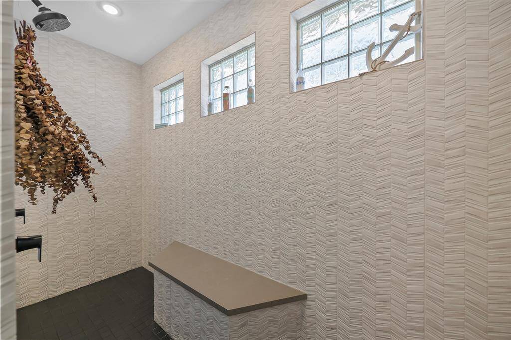 The opulent shower spans the whole back wall of the bathroom & features two separate shower heads. There is a ton of space here. Pictures don't do it justice!