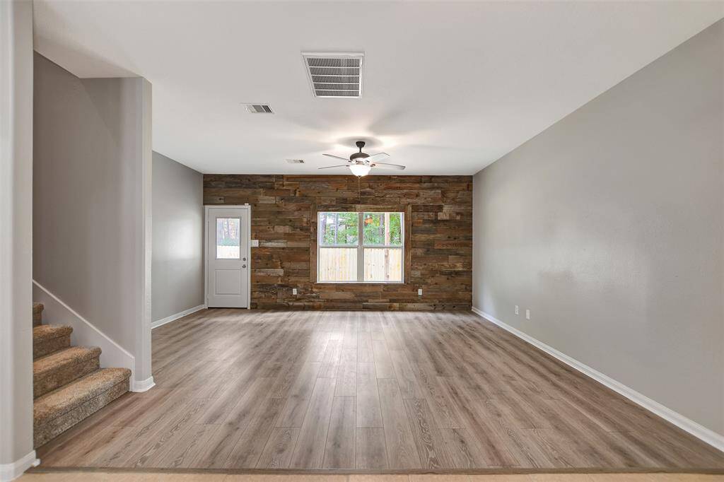 Den with rustic back wall.  New laminate floors