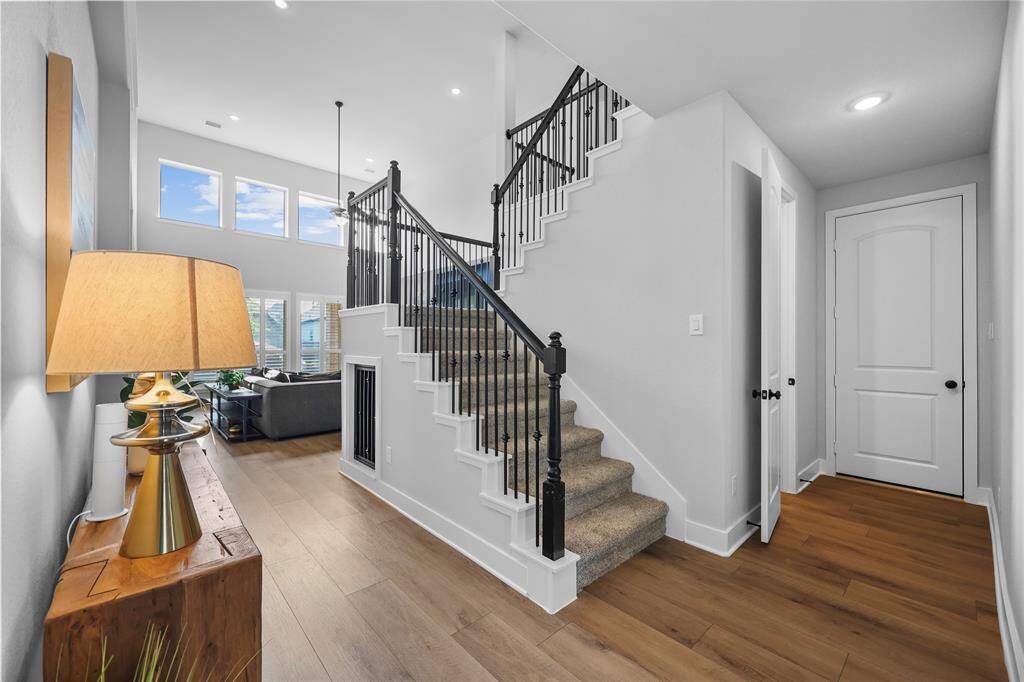 The downstairs landing gives a lasting first impression. To the right, access to the three-car garage and downstairs powder bathroom. Under the stairs you'll find a dog room with custom gate. (Not pictured are the door to the secondary bedroom DOWNSTAIRS & the dedicated home office)