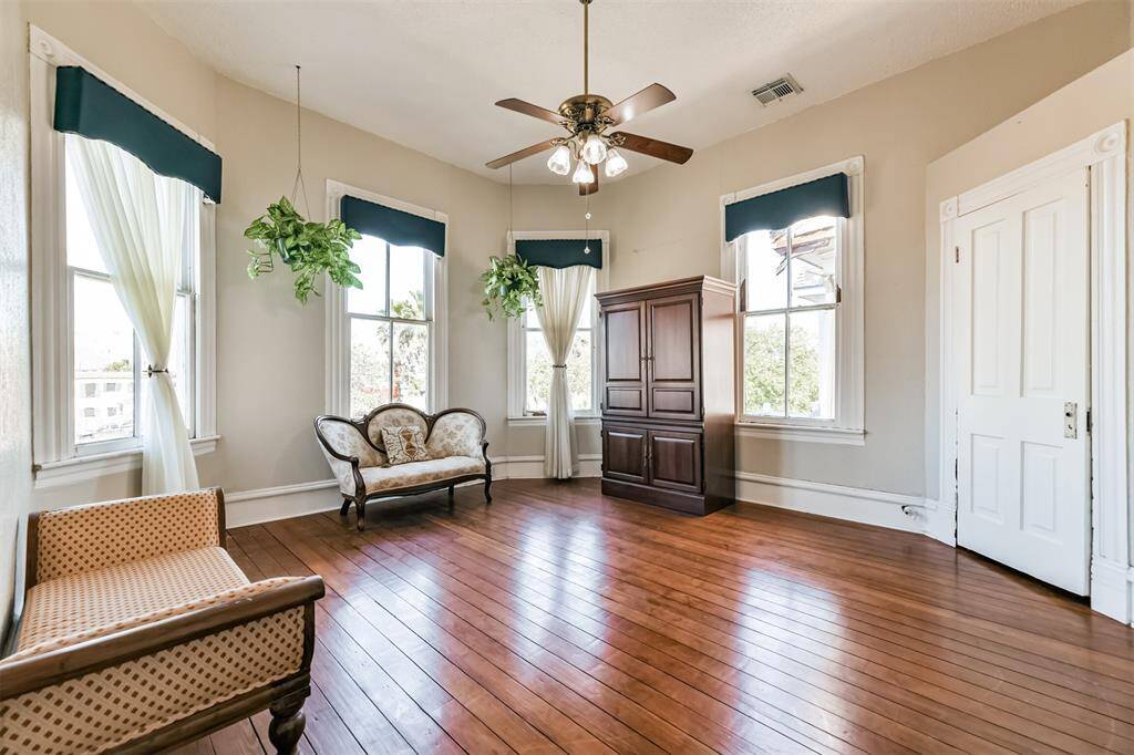 Original pocket doors trimmed with ornate moldings create separation between the master suite and the parlor, where you'll note high ceilings, a roomy closet, a lighted ceiling fan, and beautifully cased bay windows that bathe the room in natural light.