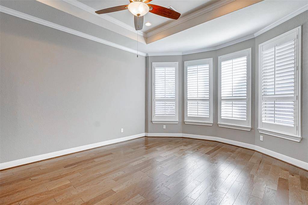 Primary Bedroom has a large bay window over looking the backyard, crown molding and a tray ceiling.