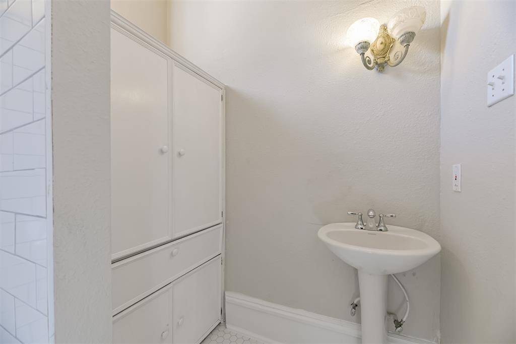An en suite master bathroom is a pretty extraordinary extravagance in a home from 1895, but this home has one! It features a pedestal sink, hexagonal tile floors, a walk-in shower, and a large built-in cabinet for storage.