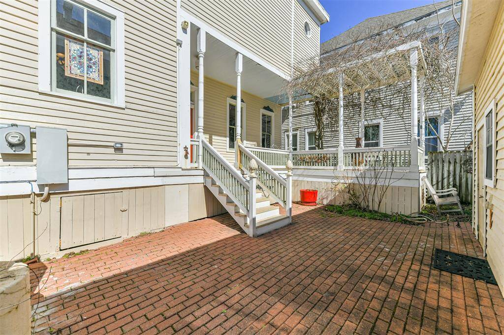 Just a few steps down from the porch of this pier & beam designed home, you'll enjoy a private fenced patio with a brick floor, a small landscaped garden area, and a grilling station.