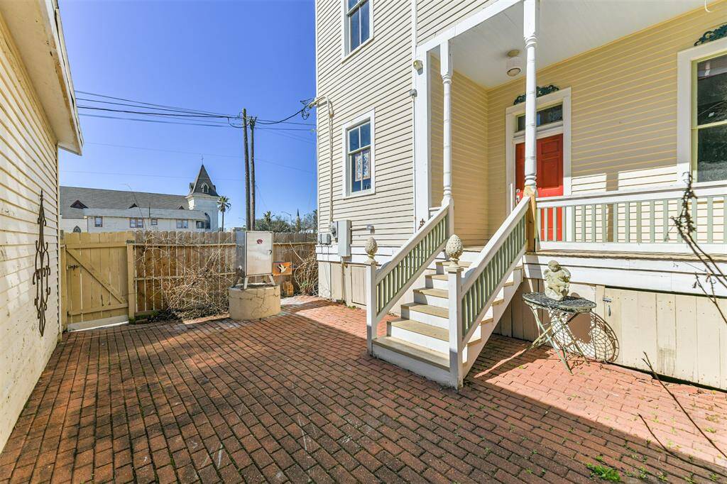 Just a few steps down from the porch of this pier & beam designed home, you'll enjoy a private fenced patio with a brick floor, a small landscaped garden area, and a grilling station.