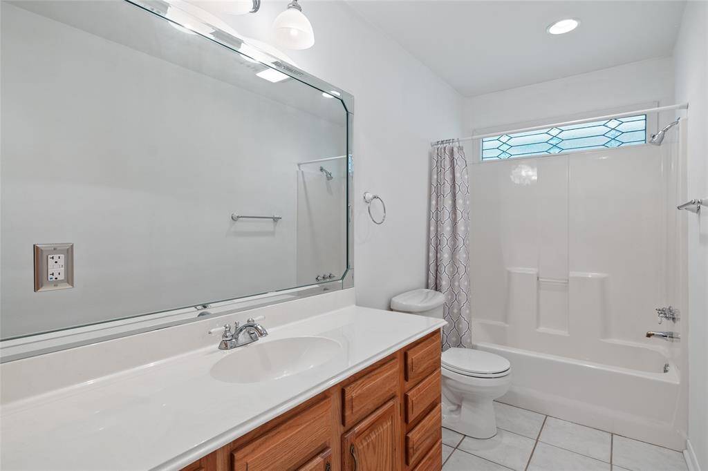 Hall Bath features large vanity with custom cabinetry, ceramic tile flooring and lots of storage.