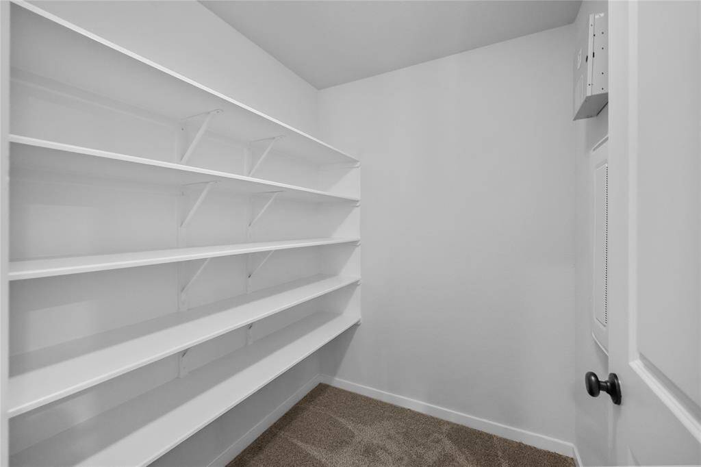 Large storage closet with shelving between bedrooms 5 and 6 features ample shelving and great space for storage.