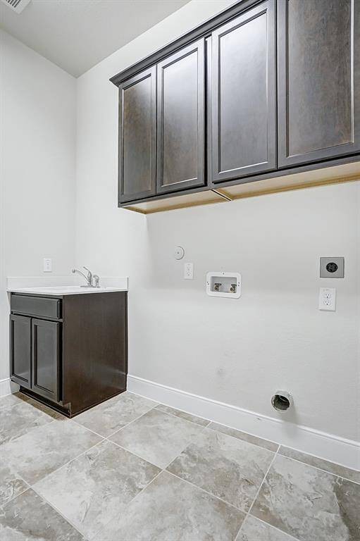 Laundry Room has cabinets for extra storage and a sink.