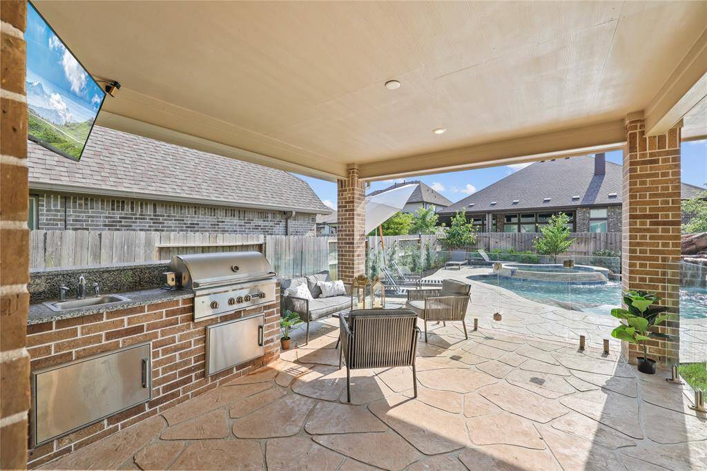 The outdoor kitchen makes this the perfect backyard for entertaining or resort-style dining. The glass paneled pool fence is a MAJOR upgrade. This item alone would cost you 10-15K to put in yourself. It ensures safety without sacrificing a great view!