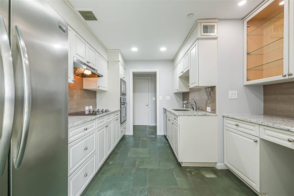 Updated kitchen features granite counters, stainless steel appliances and glass front cabinets.