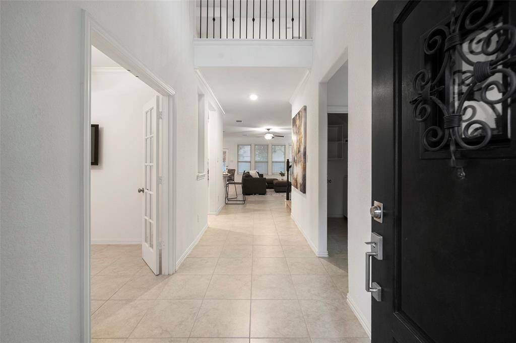 Large open foyer with tall ceilings leading to adjacent home-office!