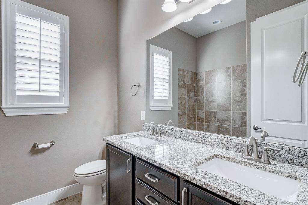 Secondary Bath. includes double sinks and a tiled shower/tub combo.