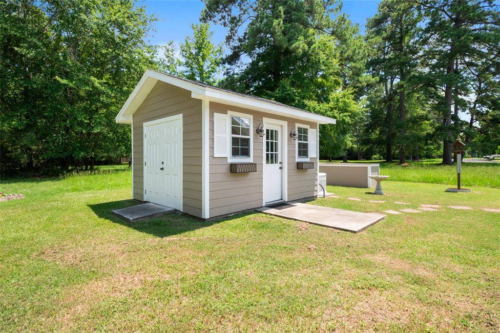 Back Yard Utility storage with work shop, space for your yard tools and riding lawnmower included in sale of property .