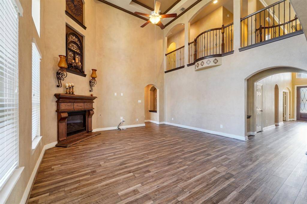 Living room with high ceilings and balcony leading to upstairs bederooms