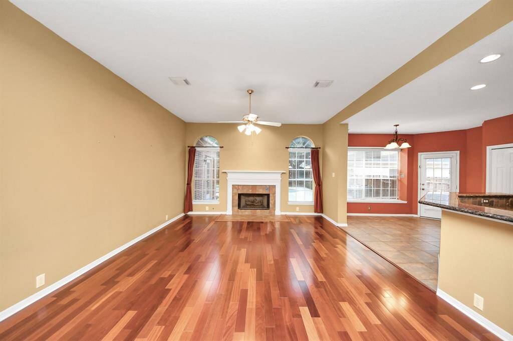 Transom windows cap off large windows that frame the fireplace and offer a view to the pool and large back yard.